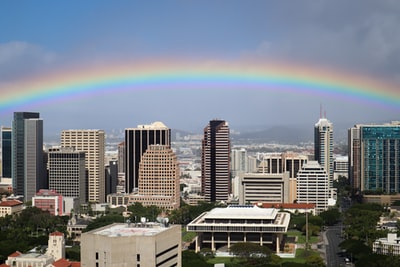 The rainbow on the city skyline during the day
